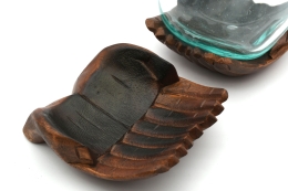 Decorative glass on carved wooden hand